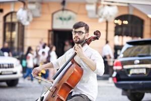 Typ, der im Sommer auf der Straße Cello spielt