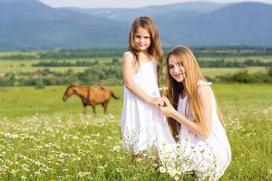 zwei hübsche Schwestern auf der Kamillenwiese foto
