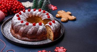 hausgemachte köstliche runde Weihnachtstorte mit roten Beeren auf einer Keramikplatte foto