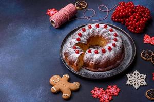 hausgemachte köstliche runde Weihnachtstorte mit roten Beeren auf einer Keramikplatte foto