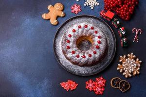 hausgemachte köstliche runde Weihnachtstorte mit roten Beeren auf einer Keramikplatte foto