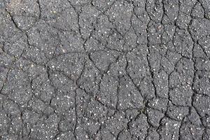 Detailansicht auf Asphaltoberflächen verschiedener Straßen und Straßen mit Rissen foto