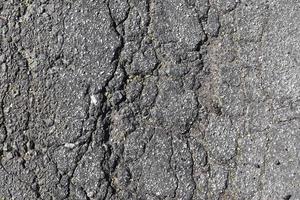 Detailansicht auf Asphaltoberflächen verschiedener Straßen und Straßen mit Rissen foto