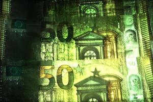 Illustration von leuchtenden Euro-Banknoten mit einer grünen Kirlian-Aura um sie herum. foto