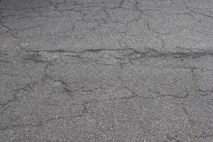 Detailansicht auf Asphaltoberflächen verschiedener Straßen und Straßen mit Rissen foto