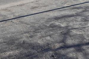 Detailansicht auf Asphaltoberflächen verschiedener Straßen und Straßen mit Rissen foto