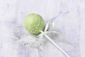 ein grüner Cake Pop auf einem strukturierten Hintergrund foto