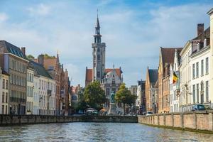 blick vom kanal auf die alten mittelalterlichen häuser, die domkirche und den platz jan van eyckplein in brügge, belgien foto
