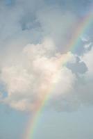 Malerischer Blick auf den Regenbogen inmitten flauschiger Wolken im Himmel an einem sonnigen Tag foto
