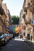 schöne bunte Dekorationen, die über Autos inmitten von Gebäuden in der Stadt hängen foto