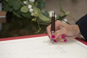 Hand beim Anmelden für die Hochzeit foto