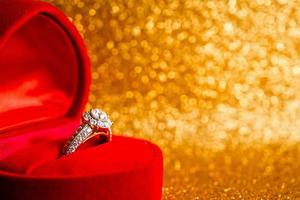 Schmuck-Diamant-Ring in Geschenkbox mit abstraktem, festlichem, glitzerndem Weihnachtsfeiertags-Textur-Hintergrundunschärfe mit Bokeh-Licht foto