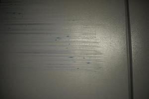 zerkratzte Oberfläche. beschädigte Farbe an der Wand. Schleifspuren. foto