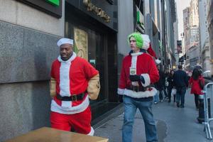 new york, usa - 10. dezember 2011 - leute, die als weihnachtsmann deressed sind, der weihnachten feiert foto