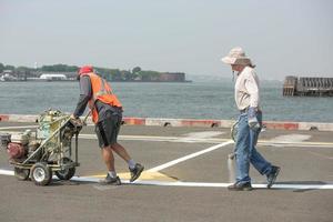 Arbeiter verfolgen Linien auf Asphalt foto