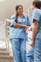 lächelnde Krankenschwester im Gespräch mit einem Kollegen
