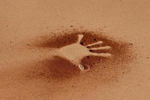 Handform der roten Erde auf Sand wie Kunststil der Aborigines foto