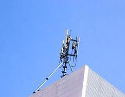 Kommunikationsturm mit Antennen auf der Spitze des Gebäudes und strahlend blauem Himmelshintergrund. foto