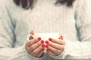 weibliche hand, die pappbecher mit kaffee zum mitnehmen auf stadthintergrund hält. Platz für Ihren Text oder Ihr Logo. foto