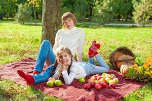 glückliche Mutter mit kleiner Tochter im Herbstpark foto