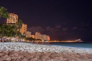 Honolulu, Usa - 14. August 2014 - Leute, die sich nachts am Sandstrand von Waikiki amüsieren foto