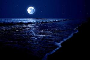 Nachthimmel über dem Meer mit Vollmond und Sternen foto