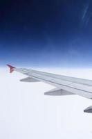 Flügel eines Flugzeugs, das über den Wolken fliegt. foto