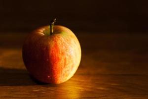 Apfel auf dem Tisch, beleuchtet von der Nachmittagssonne foto