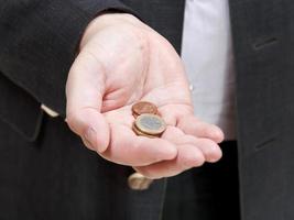 Haufen Münzen in der Hand des Geschäftsmannes foto