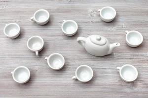 Draufsicht auf viele weiße Keramiktassen und Teekanne foto