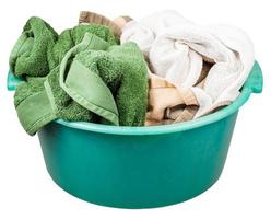 Grünes Plastikwaschbecken mit Handtüchern isoliert foto