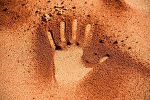 Handform der roten Erde auf Sand wie Kunststil der Aborigines foto