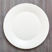 Draufsicht auf weiße Platte auf graubraunem Tisch foto