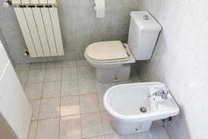 Innenbereich eines typischen weißen Toilettenraums foto