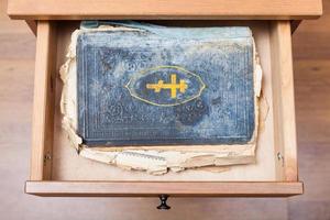altes religiöses Buch in offener Schublade foto
