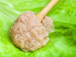 Heringskaviar im Holzlöffel auf grünem Salat foto