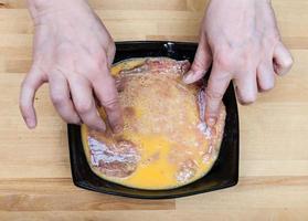 Kochen Sie ein rohes Kalbsschnitzel in Eiern foto