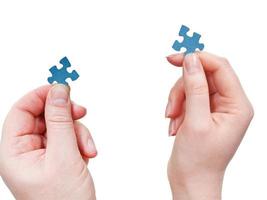männliche und weibliche hände mit kleinen puzzleteilen foto