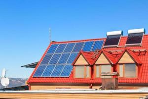 Solarbatterien und Heizungen auf dem Hausdach foto