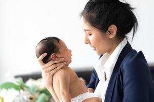 Mutter hält Baby in den Armen foto