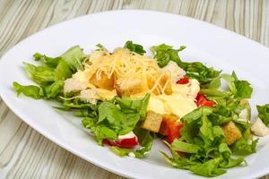 Caesar-Salat auf dem Teller und Holzhintergrund foto
