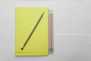 Draufsicht auf einen Notizblock und Bleistifte