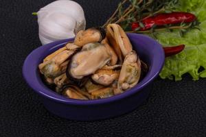 eingelegte muscheln in der schüssel serviert pfeffer, knoblauch und salat foto