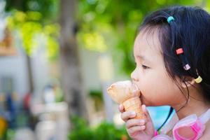 asiatisches Mädchen, das ein Eis isst foto