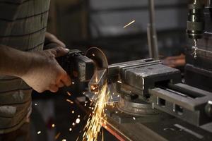 Metallbehandlung. Schleifen von Stahl. Funken von der Scheibe. Arbeit in der Werkstatt. foto