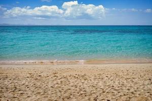 Strand und Wasser mit bewölktem blauem Himmel foto