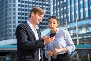 Mann und Frau, die Handy betrachten foto