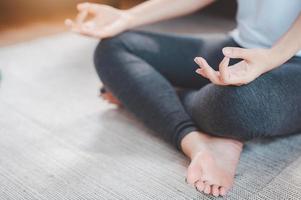 Frau, die zu Hause Yoga-Meditation praktiziert foto