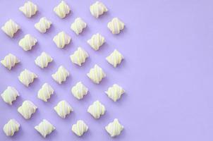 bunter Marshmallow auf violettem Papierhintergrund. kreative pastelltexturen mit kopierraum. minimal foto