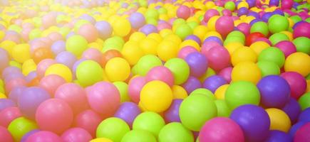 Viele bunte Plastikbälle in einem Bällebad für Kinder auf einem Spielplatz. Muster schließen foto